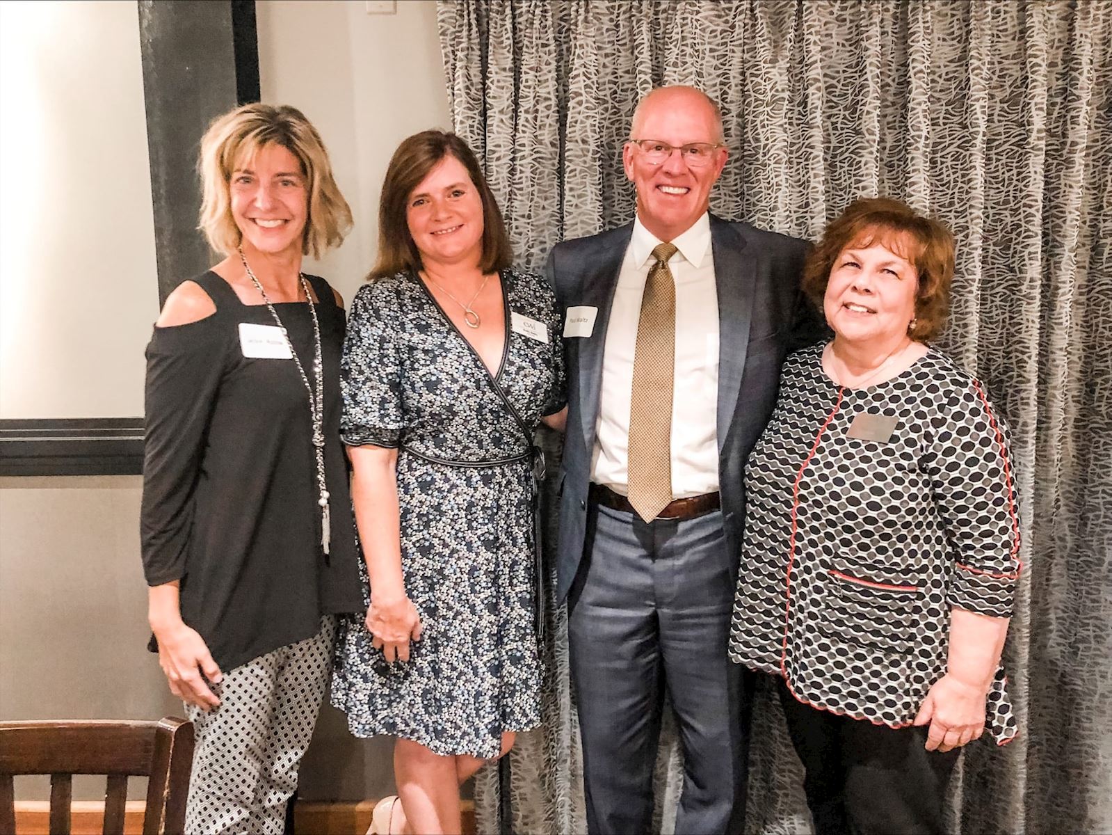 Jackie, Kelly, Paul and Deb smiling at event