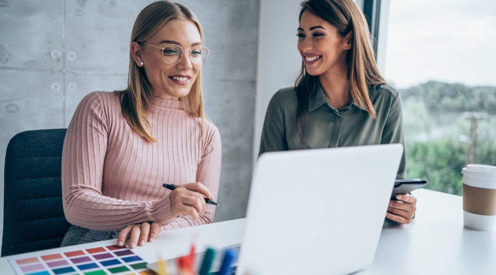 Two women at laptop with color samples