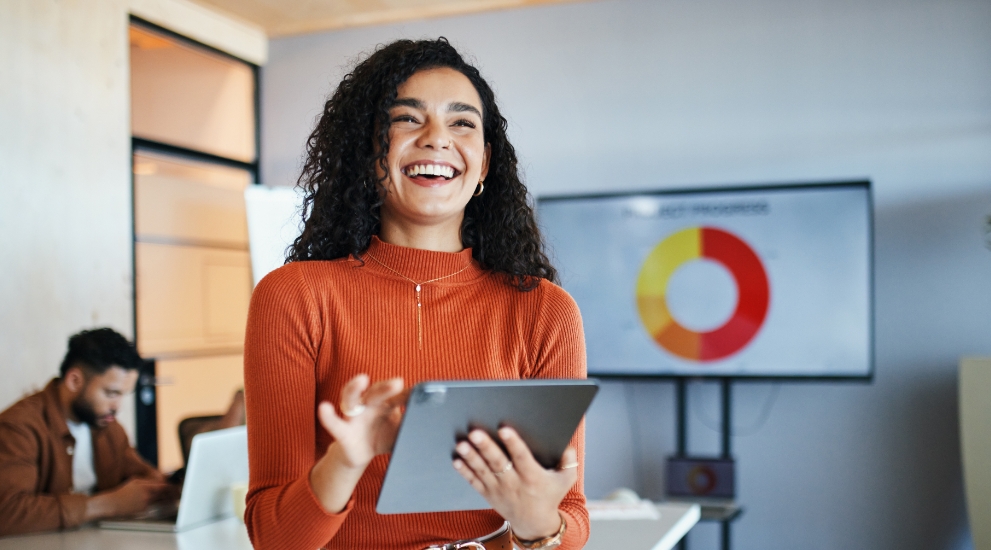 woman in boardroom with graph and ipad
