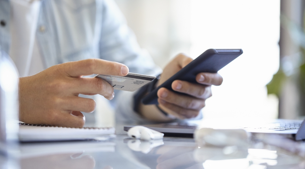 person with debit card and phone