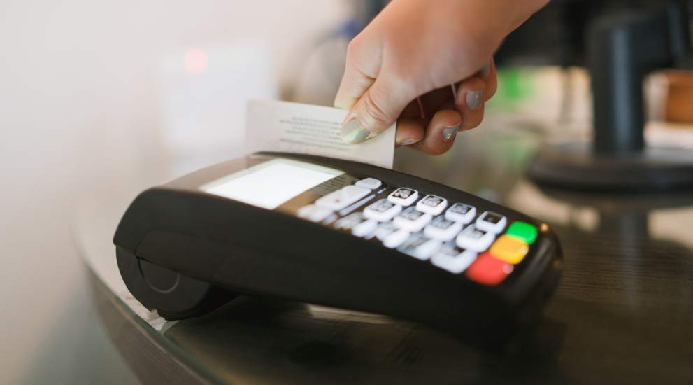 woman swipes debit card in machine