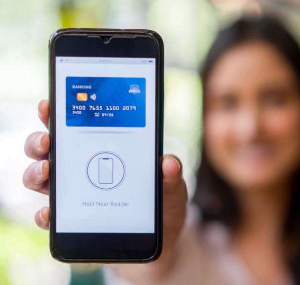 woman smiling with phone displaying debit card