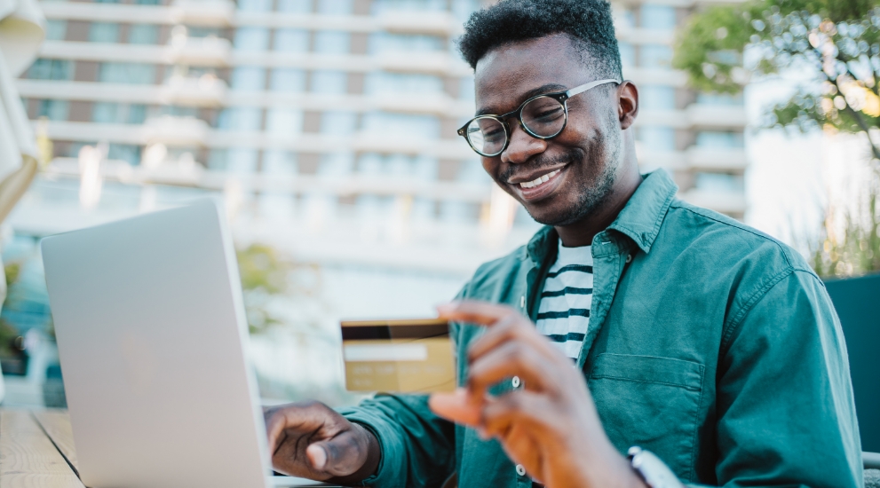 man on laptop with debit card