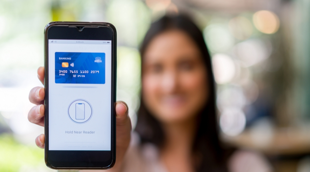 girl with cell phone and debit card on phone reader